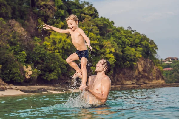 Padre e figlio che giocano sulla spiaggia durante il giorno — Foto Stock