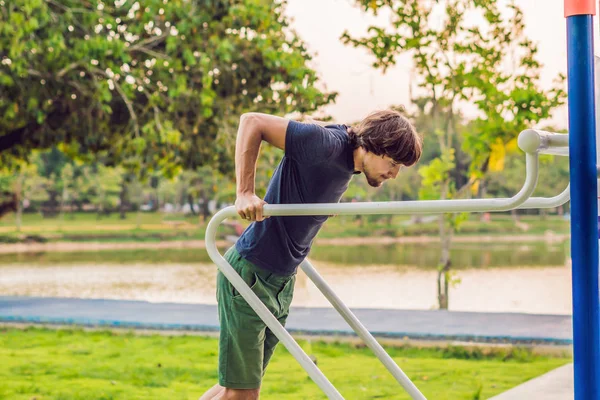 Hombre en el gimnasio de la calle en el parque — Foto de Stock