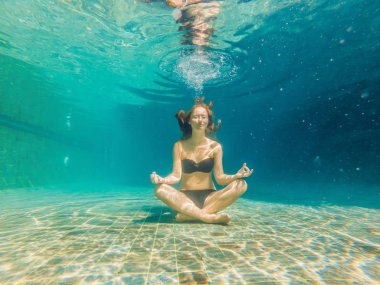 Genç kadın siyah Bikini yoga konumda sualtı dalış akvaryum, tam vücut shot, önden görünüm.
