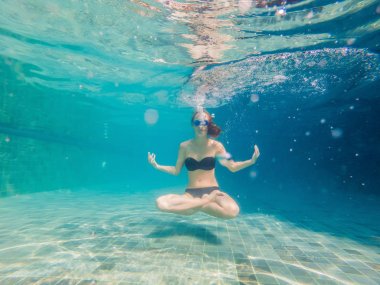 Genç kadın siyah Bikini yoga konumda sualtı dalış akvaryum, tam vücut shot, önden görünüm.