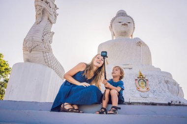 Anne ve oğlu turistlere Big Buddha heykeli. Yüksek bir inşa edilmiş Tayland Phuket edebilirsiniz tepenin bir mesafeden görülebilir