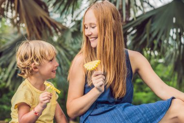 Anne ve oğlu piknik park vardı. Sağlıklı meyve - mango, ananas ve kavun yemek. Çocuk sağlıklı yemek yemek.