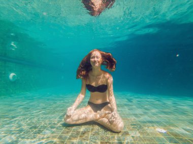 Genç kadın siyah Bikini yoga konumda sualtı dalış akvaryum, tam vücut shot, önden görünüm.