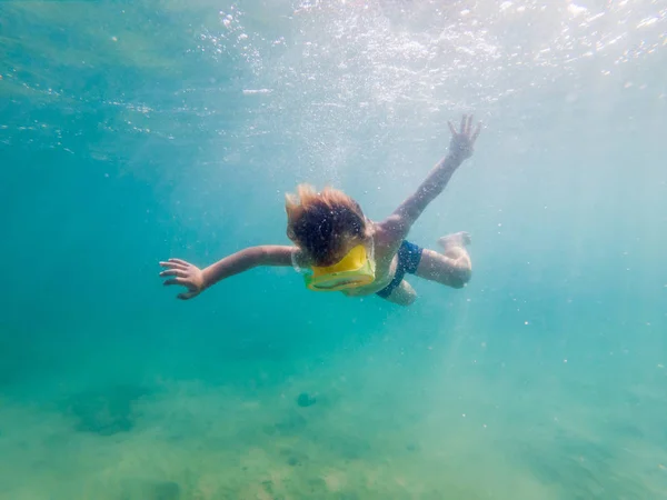 Niño con máscara de snorkel buceando bajo el agua — Foto de Stock