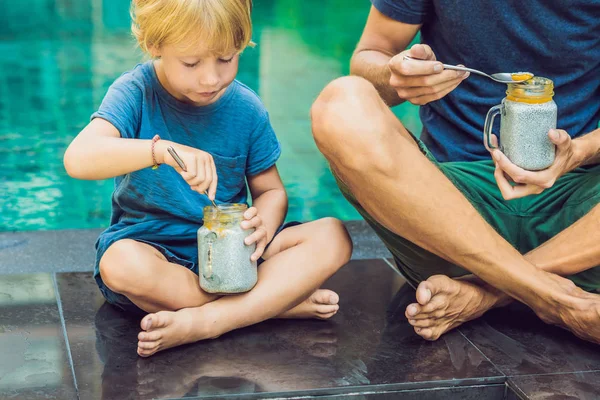 Pai Filho Comem Sobremesa Com Sementes Chia Mangas Piscina Manhã — Fotografia de Stock