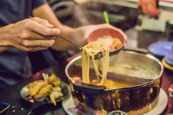 Человек кладет суп в тарелку — стоковое фото