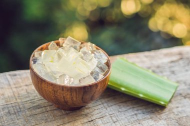 Aloe vera ve aloe küpleri ahşap bir kase içinde. Aloe Vera jel neredeyse gıda, ilaç ve güzellik sektöründe kullanımı