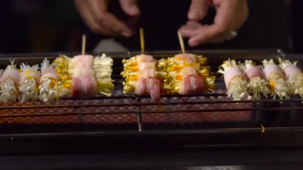 Proces van het maken van barbecue van een paddestoelen verpakt in een spek op een avondmarkt in Thailand. Thais eten concept. Aziatisch eten concept — Stockvideo