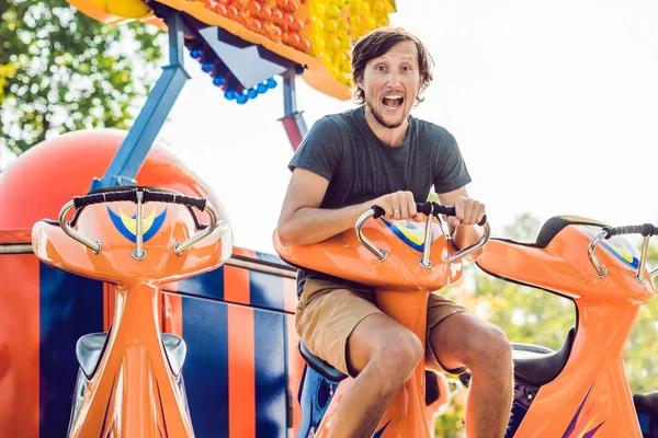 Красивый молодой человек веселится в парке развлечений — стоковое фото