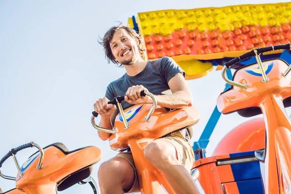 Hermoso, joven hombre divirtiéndose en un parque de atracciones — Foto de Stock