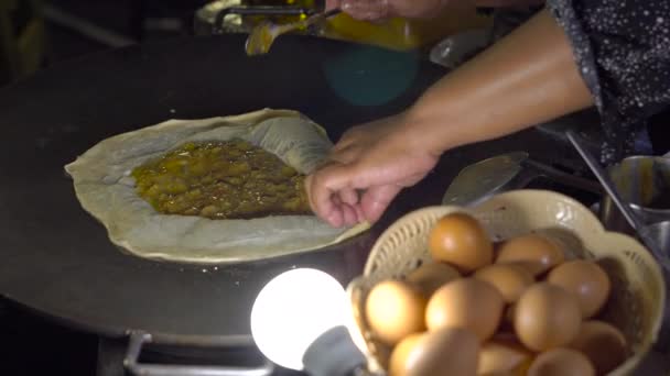 Processen av matlagning exotiska thailändska pannkakor, Malaysiska roti med olika fyllning på en nattmarknad i Thailand. Thailändsk matkoncept. Asiatisk matkoncept — Stockvideo