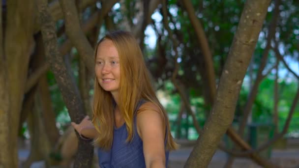 一个年轻女子坐在一个热带公园的藤本植物。假日在 tropica 概念 — 图库视频影像