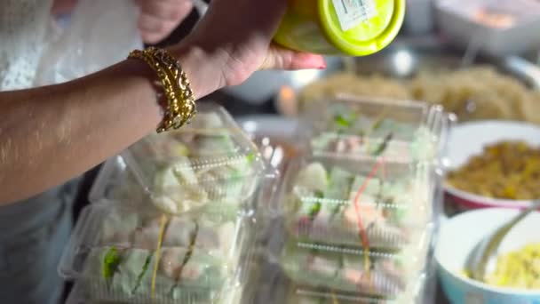 Auf einem Nachtmarkt in Thailand zahlt eine Person Geld für einen Satz Frühlingsrollen. thai food concept. Asiatisches Ernährungskonzept — Stockvideo
