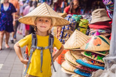 Ubud, Bali'de bir markette çocuk. Ünlü Ubud Market, Endonezya'da Hediyelik eşya ve Bali el sanatları satan tipik hediyelik eşya dükkanı. Bali pazarı. Yerel sakinlerinin ahşap ve el sanatları Hediyelik eşya