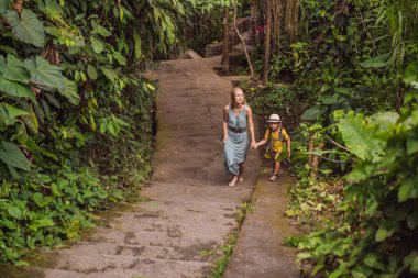 Bali 'deki anne ve oğul turistler Ubud' un dar ve rahat caddelerinde yürüyorlar. Bali popüler bir turizm merkezidir. Bali 'ye seyahat. Çocuk konseptiyle seyahat etmek