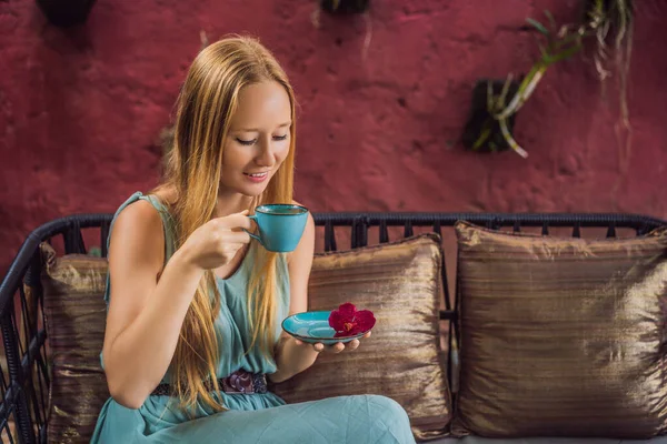 Молодая женщина, завтракающая на средиземноморском диване и пьющая горячий ароматный кофе — стоковое фото