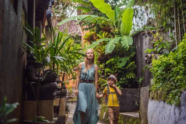 Mãe e filho turistas em Bali caminha ao longo das ruas aconchegantes estreitas de Ubud. Bali é um destino turístico popular. Viaje ao conceito de Bali. Viajar com conceito de crianças — Fotografia de Stock