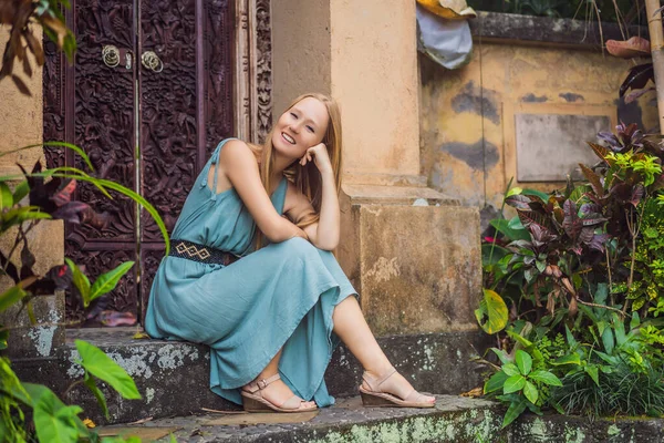 Young woman tourist in Bali walks along the narrow cozy streets of Ubud. Bali is a popular tourist destination. Travel to Bali concept — Stock Photo, Image