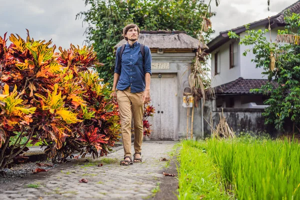 Молодой человек турист на Бали прогуливается по узким уютным улочкам Убуда. Бали - популярное туристическое направление. Концепция путешествия на Бали — стоковое фото