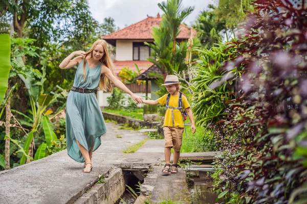 Anya és fia turisták Balin sétál a keskeny hangulatos utcákon Ubud. Bali népszerű turisztikai célpont. Utazás Balira. Utazás gyermekekkel koncepció — Stock Fotó