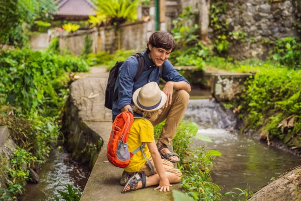 Otec a syn turisté na Bali procházky úzkými útulnými uličkami Ubud. Bali je oblíbenou turistickou destinací. Cestování na Bali. Koncept cestování s dětmi — Stock fotografie
