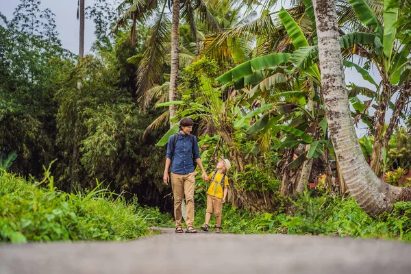 Father and son tourists in Bali walks along the narrow cozy streets of Ubud. Bali is a popular tourist destination. Travel to Bali concept. Traveling with children concept — Stock Photo, Image