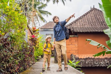 Baba ve oğul turistler Bali 'de Ubud' un dar ve rahat sokakları boyunca yürüyorlar. Bali popüler bir turizm merkezidir. Bali 'ye seyahat. Çocuk konseptiyle seyahat etmek