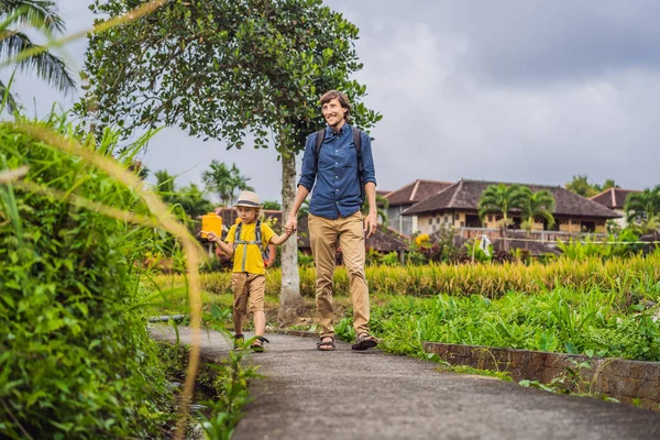 Pai e filho turistas em Bali caminha ao longo das ruas aconchegantes estreitas de Ubud. Bali é um destino turístico popular. Viaje ao conceito de Bali. Viajar com conceito de crianças — Fotografia de Stock