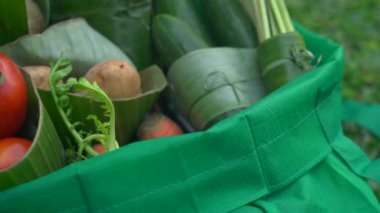 Çevre dostu ürün ambalaj konsepti. Sebzeler bir muz yaprağı sarılmış, plastik bir torba alternatif olarak. Sıfır atık kavramı. Alternatif ambalaj