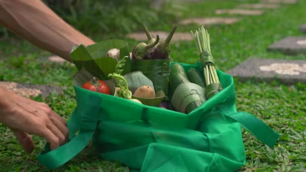 Conceito de embalagem de produto ecológico. Legumes embrulhados em uma folha de banana, como uma alternativa a um saco plástico. Zero conceito de desperdício. Embalagem alternativa — Vídeo de Stock