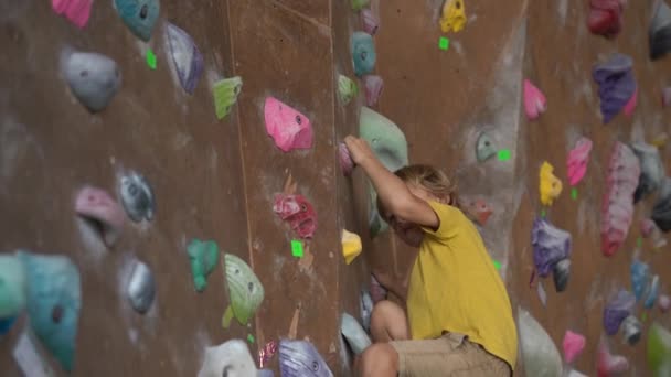 UBUD, INDONESIA - 4.08.2019: Un niño está escalando la pared en un gimnasio de escalada de rocas — Vídeo de stock