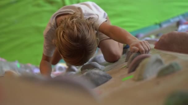 Ubud, indonesien - 4.08.2019: Ein kleiner Junge klettert die Wand in einer Boulderkletterhalle — Stockvideo