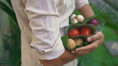 Çevre dostu ürün ambalaj konsepti. Sebzeler bir muz yaprağı sarılmış, plastik bir torba alternatif olarak. Sıfır atık kavramı. Alternatif ambalaj