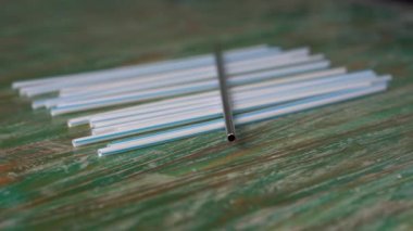 Renkli ahşap arka planda paslanmaz ve plastik pipetlerin yakın plan çekimleri. Çevre dostu alternatif kavram. Plastiksiz bir gelecek için savaş