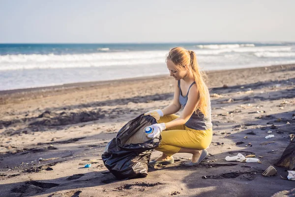 Junge Frau beim Aufräumen am Strand. Natürliche Erziehung der Kinder — Stockfoto