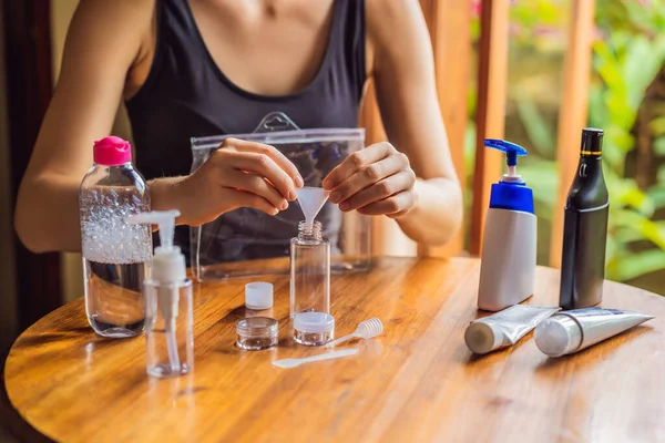 Travel kit for transporting cosmetics on an airplane. Cosmetics are ready to be poured into small bottles. A woman shifts cosmetics to take with her — Stock Photo, Image
