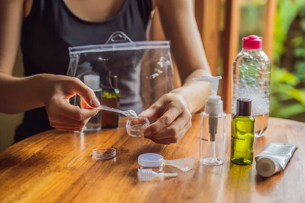 Travel kit for transporting cosmetics on an airplane. Cosmetics are ready to be poured into small bottles. A woman shifts cosmetics to take with her — Stock Photo, Image