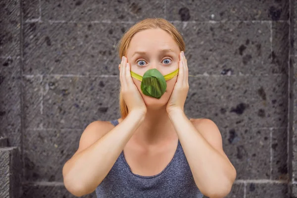 Woman made himself a face mask from the leaves to protect himself from air pollution. Air purification concept. Trees purify the air concept — Stock Photo, Image