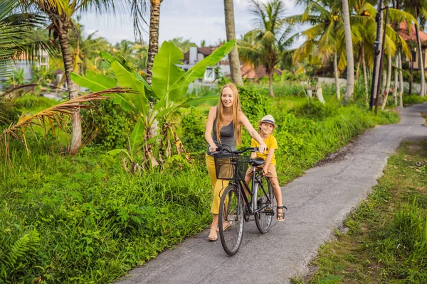 Anne ve oğlu Ubud, Bali 'de pirinç tarlasında bisiklet sürüyor. Çocuk konseptiyle Bali 'ye seyahat — Stok fotoğraf