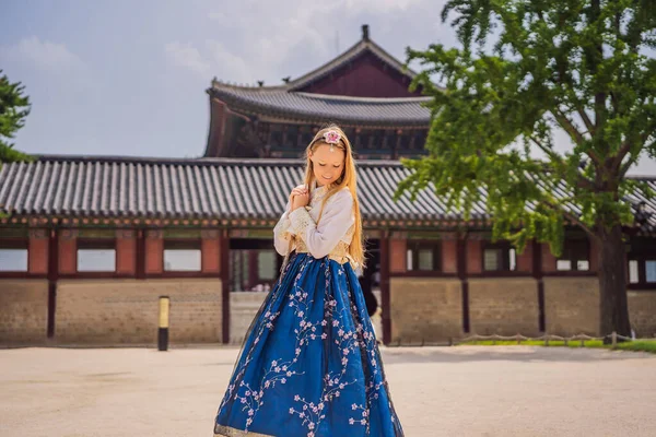 Jovem turista caucasiana em hanbok vestido coreano nacional no Palácio Gyeongbokgung. Viajar para a Coreia conceito. Roupas nacionais coreanas. Entretenimento para turistas - experimentando em coreano nacional — Fotografia de Stock