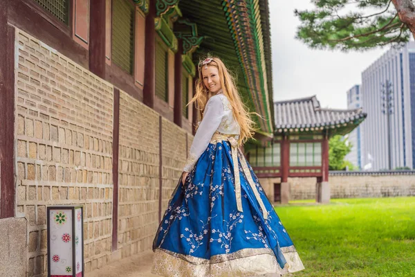 Gyeongbokgung Sarayı 'nda, Hanbok Ulusal Kore elbiseli genç beyaz kadın turist. Kore konseptine seyahat. Ulusal Kore giysileri. Turistler için eğlence - Kore 'de deneniyor — Stok fotoğraf