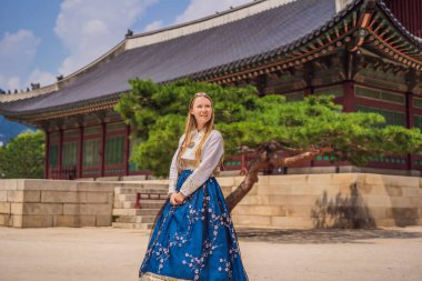 Kore Sarayı 'nda Hanbok Ulusal Kore elbisesi içinde genç beyaz kadın turist. Kore konseptine seyahat. Ulusal Kore giysileri. Turistler için eğlence - ulusal Kore kıyafetleri deniyor