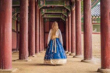 Kore Sarayı 'nda Hanbok Ulusal Kore elbisesi içinde genç beyaz kadın turist. Kore konseptine seyahat. Ulusal Kore giysileri. Turistler için eğlence - ulusal Kore kıyafetleri deniyor