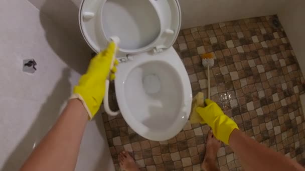 Точка зрения снимка - человек в желтых санитарных перчатках моет унитаз — стоковое видео
