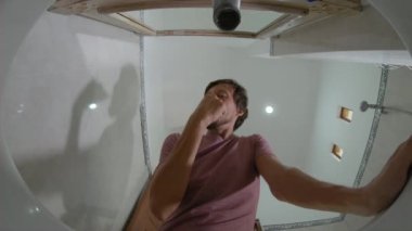 Lavabodan görüş - genç adam dişlerini fırçalıyor