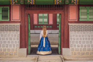 Kore Sarayı 'nda Hanbok Ulusal Kore elbisesi içinde genç beyaz kadın turist. Kore konseptine seyahat. Ulusal Kore giysileri. Turistler için eğlence - ulusal Kore kıyafetleri deniyor