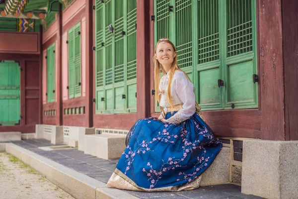 Giovane turista donna caucasica in hanbok abito coreano nazionale a palazzo coreano. Viaggio in Corea concetto. Abbigliamento nazionale coreano. Intrattenimento per i turisti - provare abbigliamento nazionale coreano — Foto Stock