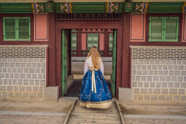 Jonge Kaukasische vrouwelijke toerist in hanbok nationale koreaanse jurk in Koreaanse paleis. Reis naar Korea concept. Nationale Koreaanse kleding. Entertainment voor toeristen - nationale Koreaanse kleding passen — Stockfoto