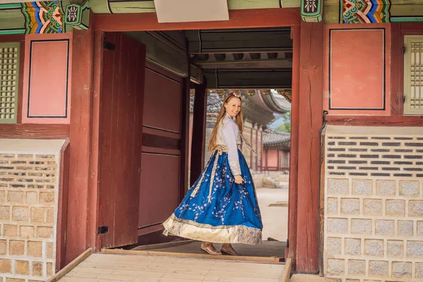 Wisatawan muda Kaukasia dengan pakaian nasional Korea di istana Korea. Perjalanan ke Korea konsep. Pakaian nasional Korea. Hiburan bagi para wisatawan - mencoba pakaian nasional Korea — Stok Foto