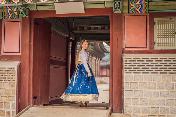 Kore Sarayı 'nda Hanbok Ulusal Kore elbisesi içinde genç beyaz kadın turist. Kore konseptine seyahat. Ulusal Kore giysileri. Turistler için eğlence - ulusal Kore kıyafetleri deniyor — Stok fotoğraf